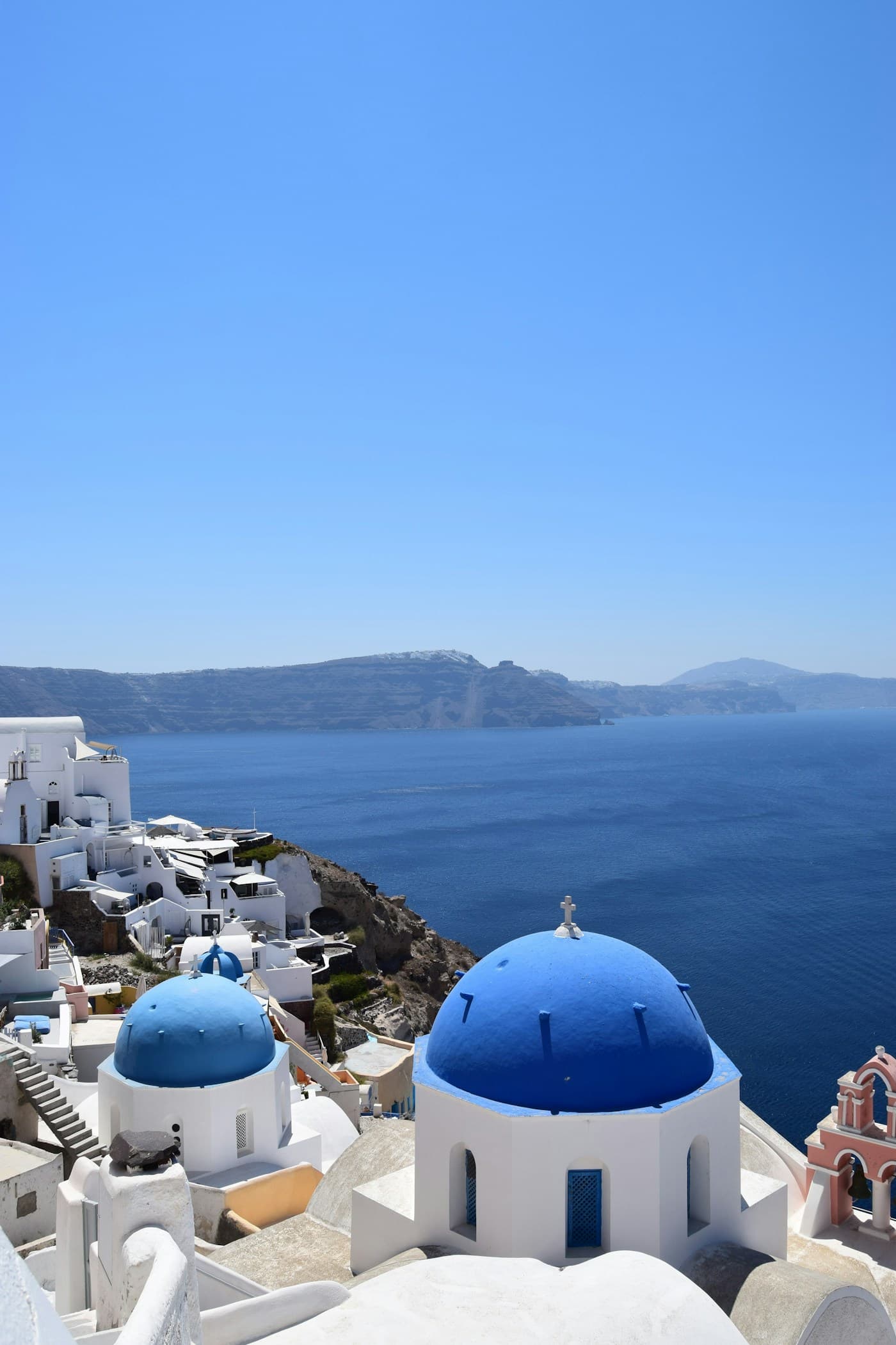 Whitewashed buildings and blue domes above the Aegean Sea in Santorini, Greece